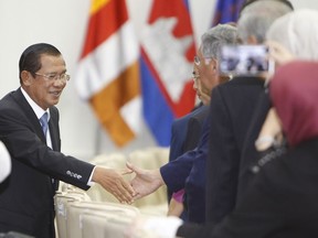 Cambodian Prime Minister Hun Sen, left, shakes hands with the international observer delegations for the July 29 general election, during a welcome meeting in Peace Palace, in Phnom Penh, Cambodia, Saturday, July 28, 2018. Cambodians voting in Sunday's elections will have a nominal choice of 20 parties but in reality, only two serious options: extend Prime Minister Hun Sen's 33 years in power or not vote at all.