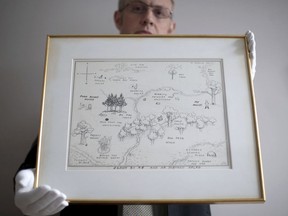 In this photo dated May 31, 2018, Philip W. Errington holds the original map of Winnie-the-Pooh's Hundred Acre Wood by E H Shepard. Shepard's 1926 hand drawn original map has sold at auction in Sotheby's in London on Tuesday July 10, 2018, for 430,000 pounds (US dollars 571,000), a record price for a book illustration.
