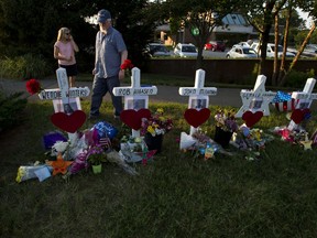 Capital Gazette reporter E.B. Furgurson III looks at the crosses representing his five colleagues at a makeshift memorial at the scene outside the office building housing The Capital Gazette newspaper in Annapolis, Md., Sunday, July 1, 2018. Jarrod Ramos is charged with murder after police say he opened fire Thursday at the newspaper.