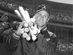 FILE - In this July 3, 1966, file photo, Atlanta Braves right-hander Tony Cloninger hoists an armload of bats after pitching the Braves to a 17-3 victory over the San Francisco Giants in which he hit two grand slams, in San Francisco. Cloninger, perhaps best known for hitting two grand slams in a game, has died. He was 77. Cloninger died Tuesday, July 24, 2018. He had worked as a consultant for the Boston Red Sox since 2002 and the team announced his death Saturday. (AP Photo, File) ORG XMIT: NY158