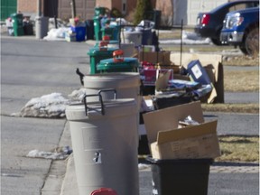 Garbage sits at the curb for pick up.