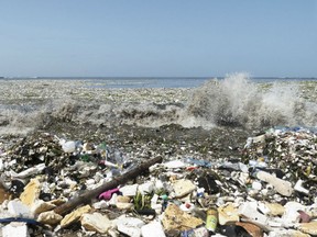 Waves coated with plastic bottles, cans, styrofoam brush up on the shore of what was once, pristine sandy beaches with tropically green trees.