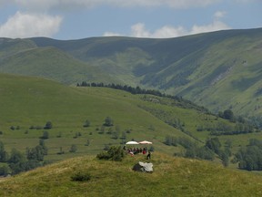 Fans picnic atop of a hill overlooking the road leading to the top of Peyragudes pass prior to the seventeenth stage of the Tour de France cycling race over 65 kilometers (40.4 miles) with start in Bagneres-de-Luchon and finish in Saint-Lary-Soulan Col du Portet pass, France, Wednesday July 25, 2018.