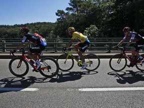 Belgium's Greg van Avermaet, wearing the overall leader's yellow jersey, rides with his teammates Italy's Damiano Caruso, left, and Tejay van Garderen of the U.S., right, during the fifth stage of the Tour de France cycling race over 204.5 kilometers (127 miles) with start in Lorient and finish in Quimper, France, Wednesday, July 11, 2018.