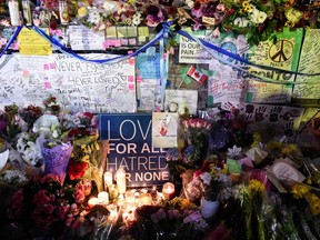 Flowers, notes and candles are piled high at a vigil on Yonge Street in Toronto, Tuesday, April 24, 2018.