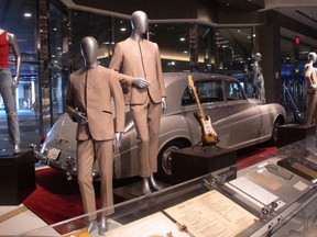 This July 5, 3018 photo shows suits worn by the Beatles during an early tour of America in front of the Rolls Royce automobile owned by Elvis Presley, part of a large collection of music memorabilia on display at the Hard Rock casino in Atlantic City, N.J.