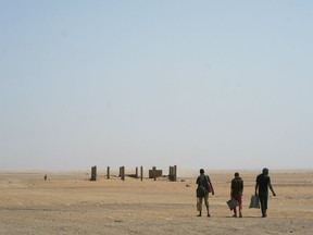 Three men head north towards Algeria after crossing the Assamaka border post in northern Niger on Sunday, June 3, 2018. The International Organization for Migration has estimated that for every migrant known to have died crossing the Mediterranean, as many as two are lost in the desert.