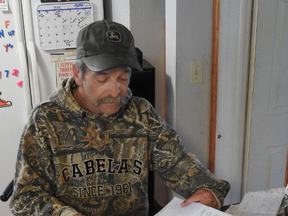 Terry Bolton goes through his power bills at his home outside of Gananoque.