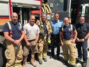 North Glengarry volunteer firefighter Chris Decoste with members of Ottawa Fire Services station 23 after putting out a house fire on Byron Avenue.