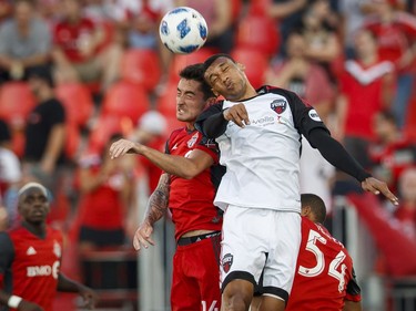 Toronto FC's Jay Chapman, left, battles for the ball with Ottawa Fury FC's Steevan Dos Santos during the first half of Canadian Championship soccer action in Toronto, Wednesday July 25, 2018.