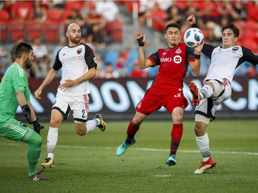 Toronto FC's Marco Delgado battles for the ball with Ottawa Fury FC's Thomas Meilleur-Giguere, right, Jeremy Gagnon-Lapare, second left, and goalkeeper Maxime Crepeau during the first half of Canadian Championship soccer action in Toronto, Wednesday July 25, 2018.