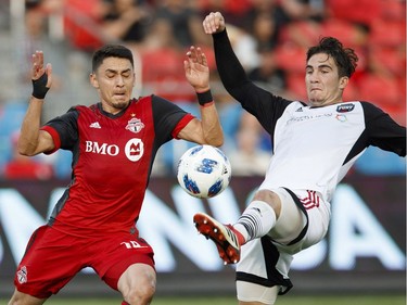 Toronto FC's Marco Delgado battles for the ball with Ottawa Fury FC's Thomas Meilleur-Giguere, right, during the first half of Canadian Championship soccer action in Toronto, Wednesday July 25, 2018.