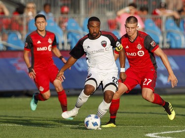 Ottawa Fury FC's Jamar Dixon, centre, battles for the ball with Toronto FC's Liam Fraser, right, during the first half of Canadian Championship soccer action in Toronto, Wednesday July 25, 2018.