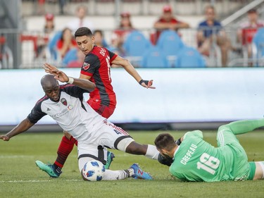 Ottawa Fury FC's Nana Attakora, left, and goalkeeper Maxime Crepeau, right, defend against Toronto FC's Marco Delgado, centre, during the first half of Canadian Championship soccer action in Toronto, Wednesday July 25, 2018.