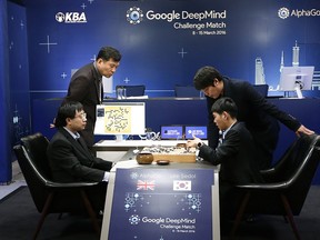 South Korean professional Go player Lee Sedol, right bottom, reviews the match with professional Go player Hong Min-pyo, right top, after finishing the second match of the Google DeepMind Challenge Match against Google's artificial intelligence program, AlphaGo in Seoul, South Korea, Thursday, March 10, 2016.