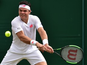 Milos Raonic returns a shot against Mackenzie McDonald at Wimbledon on July 9.