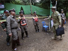Australian Federal Police and Defense Force personnel arrive near a cave in Thailand where 12 boys and their soccer coach have been trapped since June 23.