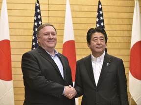 U.S. Secretary of State Mike Pompeo, left, shakes hands with Japanese Prime Minister Shinzo Abe at the prime minister's office in Tokyo, Japan, Sunday, July 8, 2018. Pompeo is on a trip traveling to North Korea, Japan, Vietnam, Abu Dhabi, and Brussels.