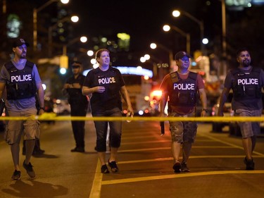 Plainclothes police work at the scene of a mass casualty incident in Toronto on Sunday, July 22, 2018.