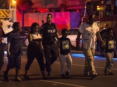 Police escort civilians away from the scene of a mass casualty incident in Toronto on Sunday, July 22, 2018.