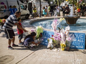 People flowers at a memorial honouring the victims of a shooting on Sunday evening on Danforth Avenue in Toronto.