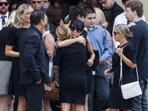 People embrace after the funeral for 18-year-old Danforth shooting victim Reese Fallon in Toronto, Monday July 30, 2018.