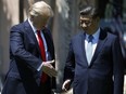 U.S. President Donald Trump and Chinese President Xi Jinping reach to shake hands at Mar-a-Lago in Palm Beach, Florida on April 7, 2017