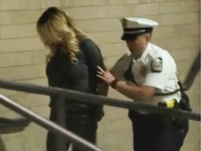 In this frame from video, porn actress Stormy Daniels is led into jail in Columbus, Ohio., after being taken into custody during a Wednesday evening, July 11, 2018, show. Daniels was arrested at a strip club and is accused of letting patrons touch her in violation of a state law, her attorney said early Thursday, July 12.