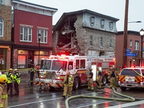 Emergency personnel deal with a collapsed wall on the side of an old building on Wellington Street near the corner of Rosemount.