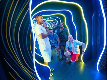 A group of friends pose in the RBC light booth as the RBC Bluesfest continues on the grounds of the Canadian War Museum at Lebreton Flats.