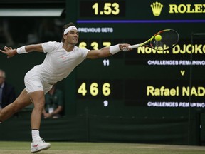 Rafael Nadal of Spain returns the ball to Serbia's Novak Djokovic during their men's singles semifinals match at the Wimbledon Tennis Championships, in London, Saturday July 14, 2018.