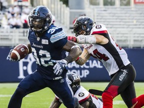 Toronto Argonauts running back James Wilder Jr. is challenged by Ottawa Redblacks defensive back Anthony Cioffi during Thursday's game. (THE CANADIAN PRESS)