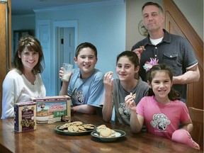 In this April 28, 2011 photo, Paula, left, and husband Chris White, standing at right, pose with their children and some of their 600 lb Gorillas frozen ice cream sandwiches and cookies in Duxbury, Mass. The 600 lb Gorillas company, which the couple founded, filed suit against ice cream supplier Mister Cookie Face, claiming millions of dollars in lost profits because the supplier changed the ice cream recipe contrary to the agreement. The case will be heard in Boston federal court in July 2018.