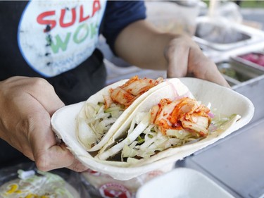 Xiao Gao prepares Asian tacos at the West End Food Truck Rally in Ottawa on Saturday, Aug. 11, 2018.