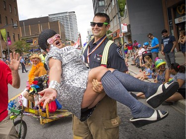 The Capital Pride Parade filled the streets with over 130 groups including community groups, sports teams, embassies and local businesses  along with thousands of spectators Sunday August 26, 2018. Parade marshal China Doll, was swept away by an Ottawa fire fighter.   Ashley Fraser/Postmedia