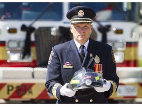 Ottawa Fire Services' Kim Ayotte, carries a helmet during the 15th Annual Ottawa Firefighters Memorial at the Ottawa Fire Fighters Monument site outside Ottawa City Hall Friday, September 9, 2016.