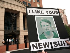 An activist holds a picture of former Trump campaign chairman Paul Manafort during a protest outside the Albert V. Bryan United States Courthouse prior to the first day of the trial of Manafort July 31, 2018 in Alexandria, Virginia.