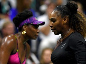 Venus Williams (L) and Serena Williams of the United States change ends during their women's singles third round match on Day Five of the 2018 US Open at the USTA Billie Jean King National Tennis Center on August 31, 2018 in the Flushing neighbourhood of the Queens borough of New York City.