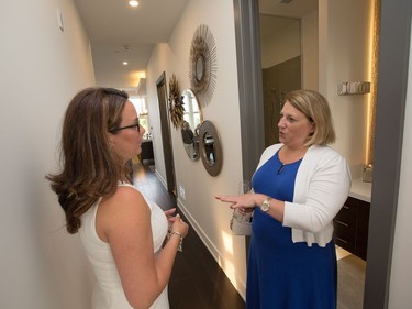 Listing agent Dominique Milne (L) chats with guest Nancy Rheaume .