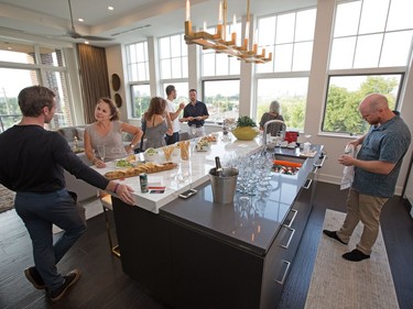 Clients and agents gather in the kitchen area in the luxury condo at 12 Stirling.