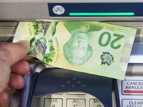 Money is removed from a bank machine.