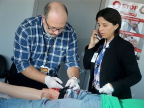 Nurse and Trauma Coordinator at the Ottawa Hospital's Trauma program, Mathieu Lebreton (left), along with Injury Prevention Coordinator and fellow nurse,  Sonshire Figueira, demonstrate applying a tourniquet to a wound as part of the hospital's new program, Stop the Bleed.