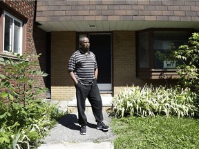Abdullahi Ali stands outside his Heron Gate residence in Ottawa on Saturday, Aug. 11, 2018. A sign placed in his front window reads "I AM NOT MOVING."
