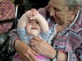 A senior at Forest Valley Residence in Orleans,  Carol Huggard, gets a laugh from her little volunteer, Leah Laforge, six months.
