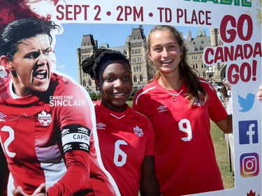 Canadian team members Deanne Rose, left, and Jordyn Huitema pose playfully with a card picture on Parliament Hill on Thursday.  Julie Oliver/Postmedia