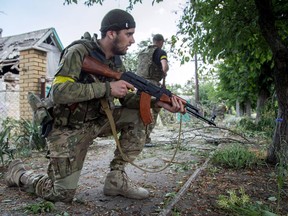Ukrainian servicemen hold guns during fightings in the Ukrainian city of Mariinka, in the region of Donetsk on June 4, 2015.