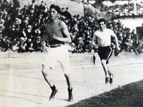 This black and white action photograph of Tom Longboat shows the marathon runner competing on a track.