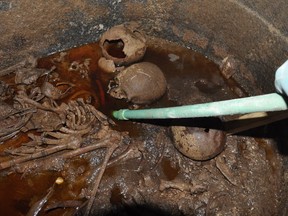 A handout picture released on July 19, 2018 by the Egyptian Antiques ministry shows skeletons in the black granite sarcophagus uncovered early this month in the Sidi Gaber district of Alexandria, filled with sewage water.