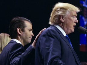 In this file photo taken on November 7, 2016 Donald Trump, Jr., (L) places a hand on the shoulder of his father, Republican presidential nominee Donald Trump, during in a rally on the final night of the 2016 U.S. presidential election in Manchester, New Hampshire.