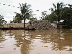 A general view shows houses partially submerged by floodwaters in Hpa-an, Karen state on July 30, 2018. Rising floodwaters have killed at least five people and forced tens of thousands from their homes across swathes of Myanmar, a government official told AFP on July 29, as heavy monsoon rains continue to batter the Mekong region.